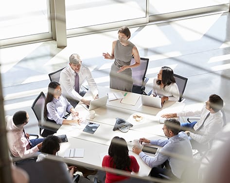 Female manager addressing a meeting, seen from stairs